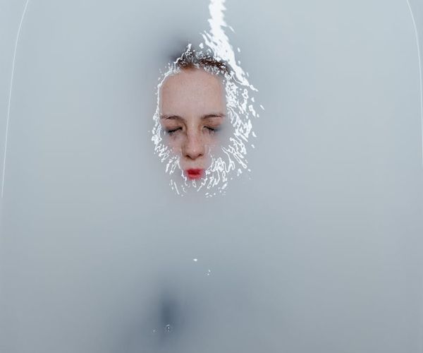 Person meditating peacefully with a serene expression on their face.